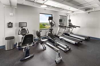 A gym with four treadmills and other exercise equipment